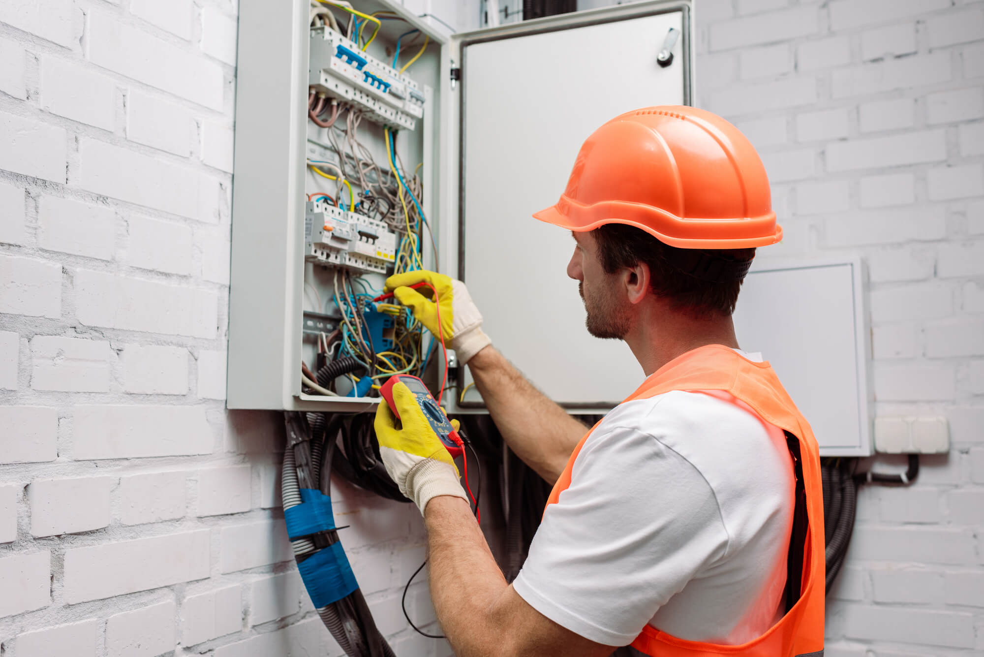 Electrician contractor with red safety helmet and yellow gloves